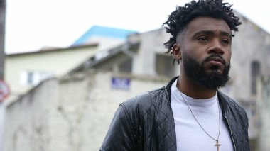 Düşünceli genç bir siyah adam şehir sokağında yürüyor düşünceli bir Afrikalı.