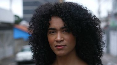 A confident black woman standing outside looking at camera
