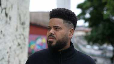 Şehir sokağında dikilen sıradan, genç bir zenci.