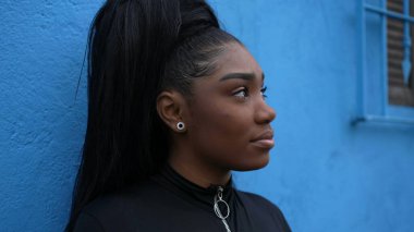 Düşünceli siyah bir kız düşünceli bir Afrikalı kadın dışarıda duran hayatı düşünüyor.