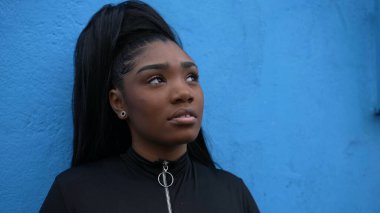 Düşünceli siyah bir kız düşünceli bir Afrikalı kadın dışarıda duran hayatı düşünüyor.