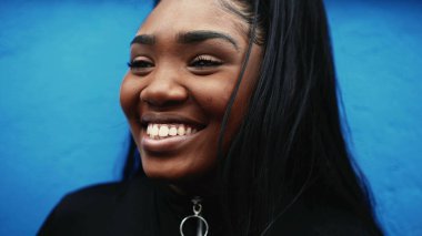 Siyahi bir Afrikalı kadın gülümsüyor, mutlu ve samimi.