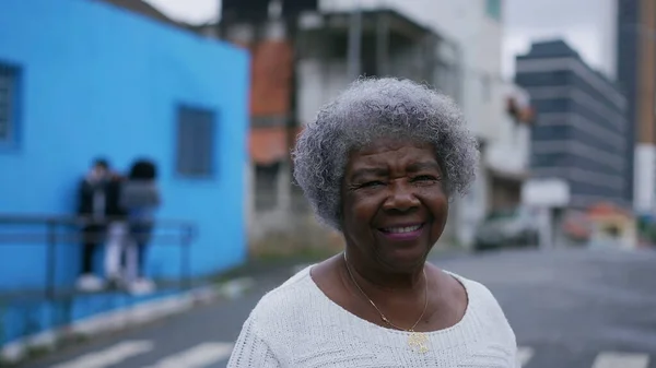 A Brazilian latin older woman in 70s with gray hair outside in urban street tracking shot