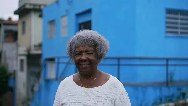 A Brazilian latin older woman in 70s with gray hair outside in urban street tracking shot