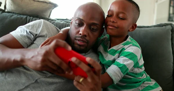 Pai Criança Juntos Assistindo Conteúdo Dispositivo Smartphone Menino Africano Abraçando — Fotografia de Stock