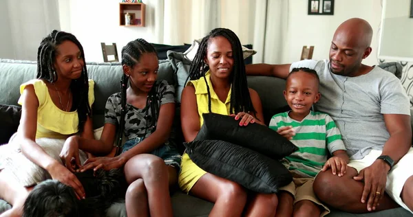 Candid authentic black African family together in living-room sofa