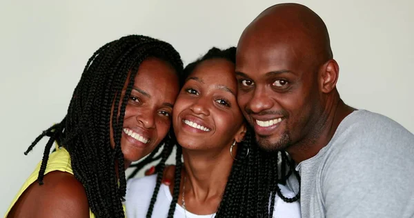 Beautiful Black African family smiling at camera. Mixed race father, mother, and teen daughter