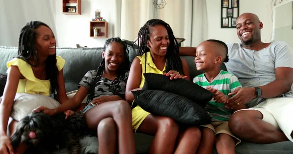 African family together at home couch. Black ethnicity parents and children living-room sofa, love and affection