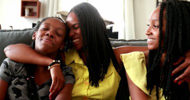 Afrika kökenli Amerikalı anne ve kızı dizüstü bilgisayarlarında internete bakıyorlar.