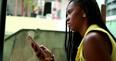 Akıllı telefondan mesaj yazan kadın, cep telefonu kullanan Afrikalı siyah ırk.