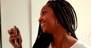 Ergen bir kız aynadaki yansımanın önünde selfie çekiyor. Siyah Afrika etnik kökeni