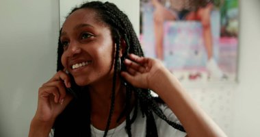 Genç kız telefona cevap veriyor. Afrikalı ergen kız akıllı telefondan konuşuyor.