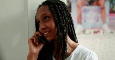 Genç kız telefona cevap veriyor. Afrikalı ergen kız akıllı telefondan konuşuyor.