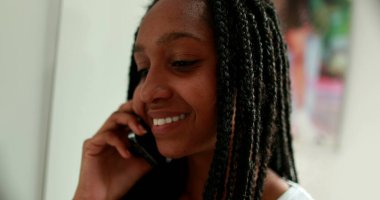 Genç kız telefona cevap veriyor. Afrikalı ergen kız akıllı telefondan konuşuyor.