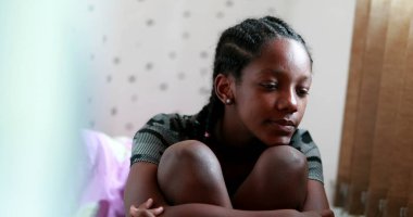 Pensive Black teen girl child thinking. Thoughtful sad depressed teenager adolescent girl