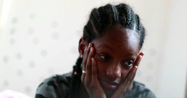 Pensive Black teen girl child thinking. Thoughtful sad depressed teenager adolescent girl