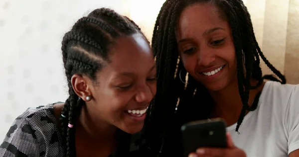 Two Girls Laughing Looking Cellphone Device Black Ethnicity Girlfriends — Stockfoto