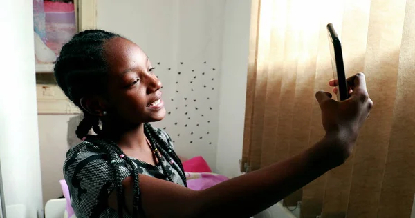 African girl waving hello to camera speaking on video with smartphone device