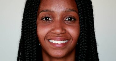 Genç siyahi kadın kameraya gülümsüyor, Afro-Amerikan kız portresi yakından gülümsüyor.