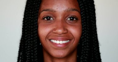 Genç siyahi kadın kameraya gülümsüyor, Afro-Amerikan kız portresi yakından gülümsüyor.