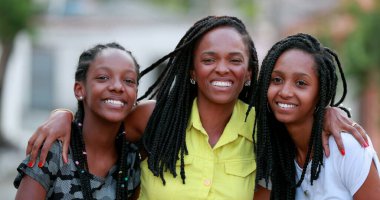 Komik anne dışarıda kızlarına sarılıyor. Afrikalı siyah etnik köken aile sevgisi ve sevgisi