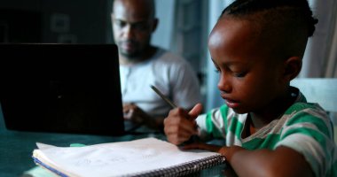 Evde bilgisayar kullanarak birden fazla iş yapan bir baba. Samimi özgün ve gerçek hayatta baba çalışıyor ve ebeveynlik yapıyor.