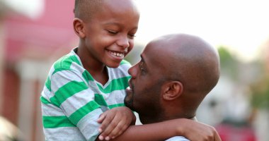 Father and son love care and affection. African dad cuddling with child son