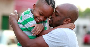 Father and son love care and affection. African dad cuddling with child son