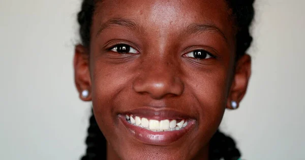 Happy black African girl close-up face smiling at camera. Portrait teen