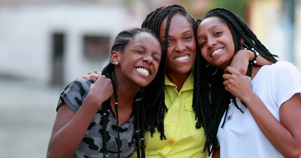 Komik anne dışarıda kızlarına sarılıyor. Afrikalı siyah etnik köken aile sevgisi ve sevgisi