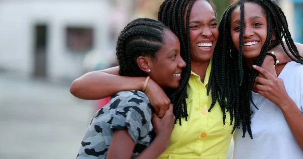 Komik anne dışarıda kızlarına sarılıyor. Afrikalı siyah etnik köken aile sevgisi ve sevgisi