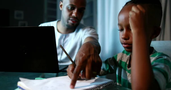 Father multi-tasking using computer laptop at home. Candid authentic and real life dad working and parenting