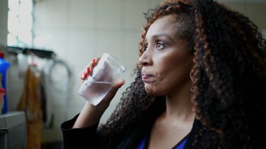 Camdan su içen siyah bir kadın tatlı su içer.