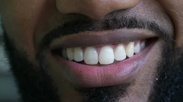 A black man macro eyes smiling at camera close-up face smile