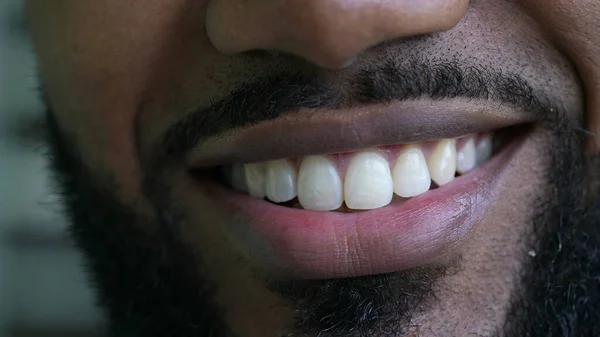 A black man macro eyes smiling at camera close-up face smile