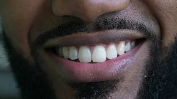 A black man macro eyes smiling at camera close-up face smile