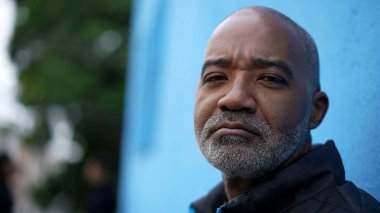 Kameraya yakından bakan ciddi bir siyah kıdemli adamın portresi.