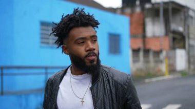 Şehir sokaklarında yürüyen genç bir adam öne doğru yürür.