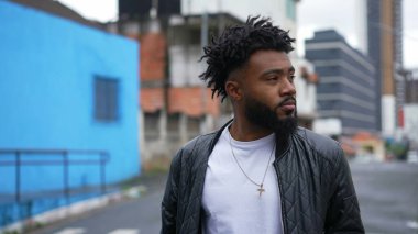 Şehir sokaklarında yürüyen genç bir adam öne doğru yürür.