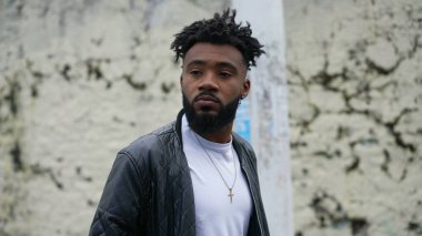 Şehir sokaklarında yürüyen genç bir adam öne doğru yürür.