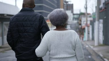 Baba ve 80 'lerin annesi sokakta birlikte yürüyorlar.