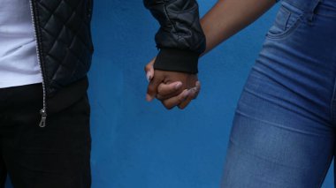 Çift el ele tutuşuyor. Siyahi bir adam ve kadın destek ve aşk.