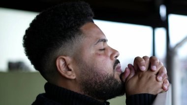 Umutla Tanrı 'ya dua eden genç bir adam
