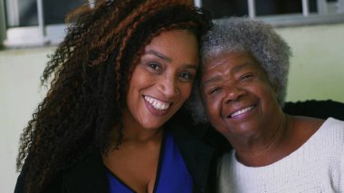 Adult daughter and older senior mother portrait faces