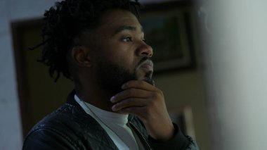 Düşünceli bir siyahi adam düşünceli bir Afrikalı 'nın ikilemi düşündüğünü düşünüyor.