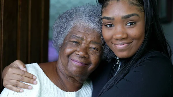 A teen granddaughter embracing grandmother a black girl embraces grandparent