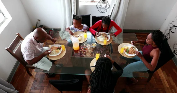 African family eating lunch together. Black parents and kids eating meal, top view