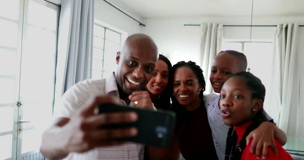 African family cheering success together looking at cellphone