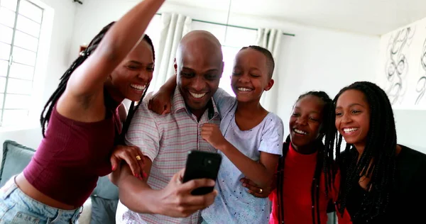 African family celebrating success cheering holding cellphone device