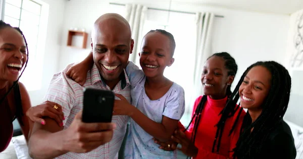 African family celebrating success cheering holding cellphone device